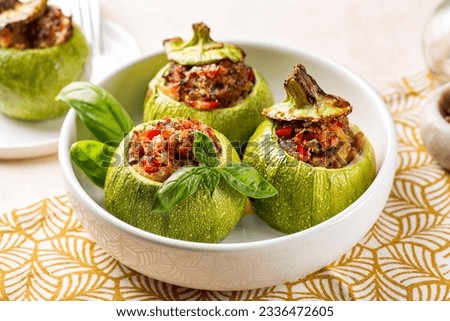 Italian style Stuffed round Zucchini with sausage, hard cheese parmesan, bell pepper, egg and bread crumbs filling in a white bowl.