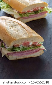 Italian Sub Sandwich With Ham And Genoa Salami On Slate Kitchen Table