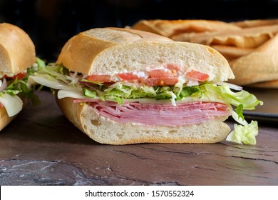 Italian Sub Sandwich With Ham And Genoa Salami On Slate Kitchen Table