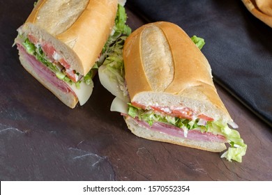 Italian Sub Sandwich With Ham And Genoa Salami On Slate Kitchen Table