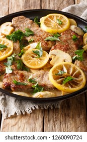 Italian Veal Scaloppini With Mushrooms And Lemons In A Sauce Close-up In A Frying Pan On The Table. Vertical
