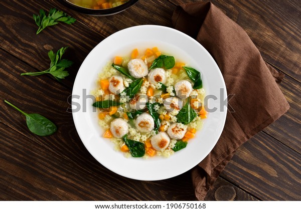 Italian wedding soup with meatballs,\
vegetables and small pasta in bowl over wooden background. Healthy\
diet dish for dinner. Top view, flat\
lay\

