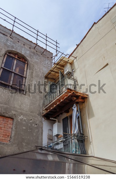 Italian\
yard with buildings, cars and bicycles, cobblestone patio. Yellow\
facade of a nice building with entrance doors decorated with\
carving. Car2go. Urban landscape. Italy,\
Florence