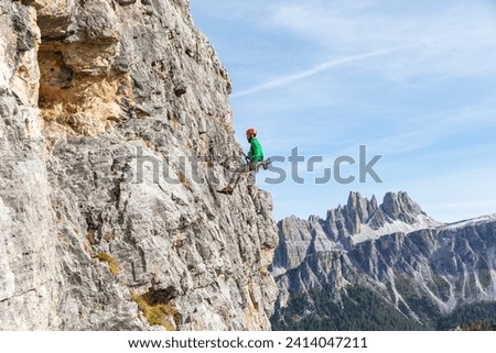 Italy- cortina d'ampezzo- man abseiling in the dolomites mountains
