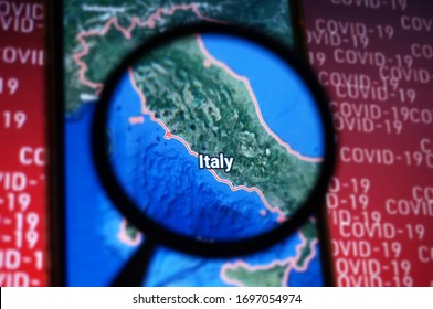 Italy country on google maps under magnifying glass with Red Covid-19 text Background. Selective Focus.                             