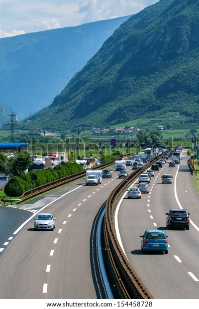 ITALY - JULY 7: Loaded\
cars driving on the highway during summer vacation on July 7, 2013\
in Italian Alps.