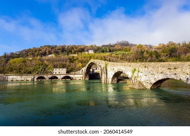 Italy, Lucca. The emerald cold water of the river reflects the ancient asymmetrical arches of the bridge. The bridge of Mary Magdalene crosses the Serchio River. 