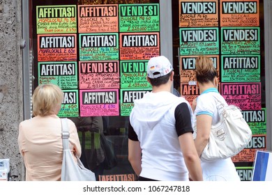 Italy , Milan April 12,2018 - Real Estate Agency - People  Look At The Window Looking For A House To Rent, Sell Or Buy