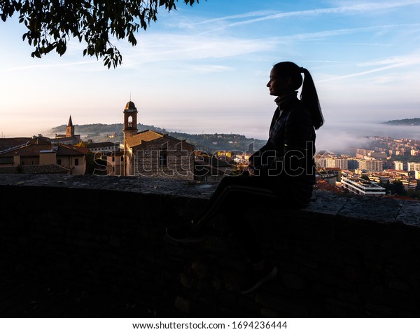 Italy, Perugia\
November 2019. Profile of a girl on the background of the landscape\
of the old city of\
Perugia.\
