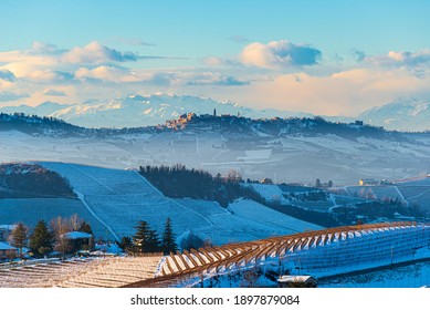 Italy Piedmont: Barolo wine yards unique landscape winter sunset, La Morra medieval village castle on hill top, the Alps snow capped mountains background, italian heritage grape agriculture