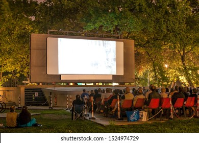 Italy, Rome, August 6, 2011: People Watch A Movie In A Street Cinema In A Park At Night.