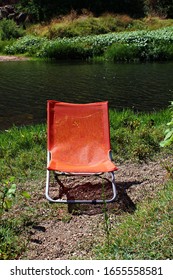 Italy, Sardinia: Orange Deckchair On The River.