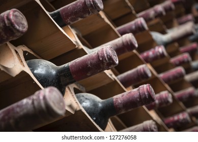 Italy, Sicily, Old Red Wine Bottles Aging In A Wine Cellar