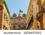 Italy, Sicily, Trapani Province, Trapani. Clock tower with the Italian flag in the city center of Trapani.