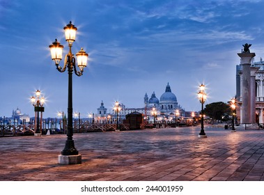 Italy Venice sunrise view on st marco square and Sana Maria Della Salute cathedral with lighting street lamps - Powered by Shutterstock