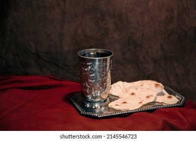 Items For Church Communion Chalice With Wine And Bread On A Platter On A Red Fabric For Easter Remembrance