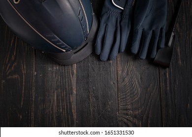 Items Of Equipment Of Horse Jockey, Jockey. Helmet, Gloves, Whip On Black Table