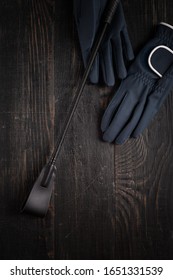 Items Of Equipment Of Horse Jockey, Jockey. Helmet, Gloves, Whip On Black Table