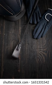 Items Of Equipment Of Horse Jockey, Jockey. Helmet, Gloves, Whip On Black Table