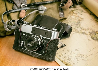 Items needed for travel: a large backpack, camera, map of the world. Vintage items in retro style.