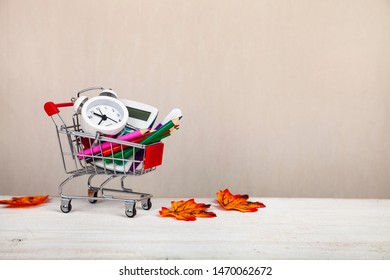 Items For School In A Shopping Cart And Autumn Leaves. Back To School.