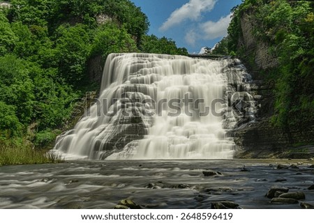 Ithaca Falls cascades dramatically down the rock formation from Fall Creek into Cayuga Lake in Ithaca, New York, USA