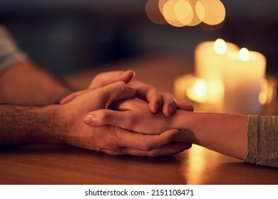 Itll be okay. Closeup of two unrecognizable people holding hands over a dinner table with candle light in the background. - Powered by Shutterstock