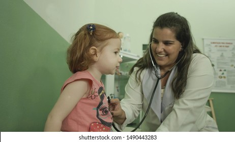 Itu, BRAZIL - 16 March 2016: Redhead Girl Being Examined By Female Doctor With Stethoscope At Health Clinic In Itu City In The Morning.