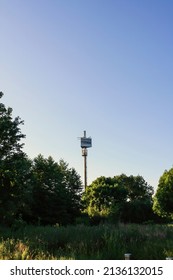 Itzehoe, Germany - Jun 2010: Hightech Itzehoe antenna tower with trees and grass in clear blue sky background. No people.