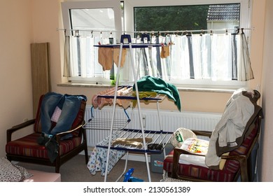 Itzehoe, Germany - Jun 2010: View Of Messy Small Room With Laundry Hanger And Windows In Cheap And Affordable Apartment. No People.