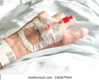 IV Cannula In A Hand Relaxing In Hospital Bed.