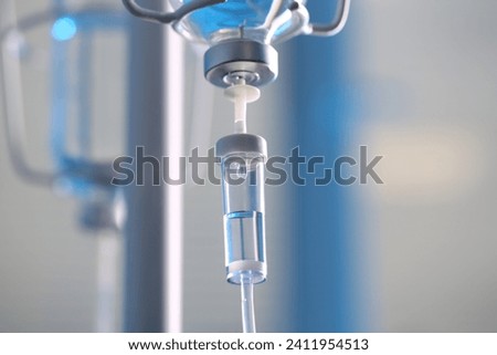 IV drip chamber against blurred light background