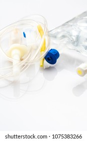 IV Drip Chamber, Tubing, And Bag Of Solution On A White Table In A Hospital.