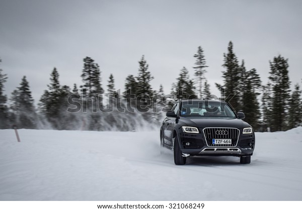 IVALO, FINLAND - February 15, 2015: Winter tire\
test is held at the proving ground. Test-driver performs snow\
handling test to determine the tire which provides the best grip on\
snow. SUV on display.