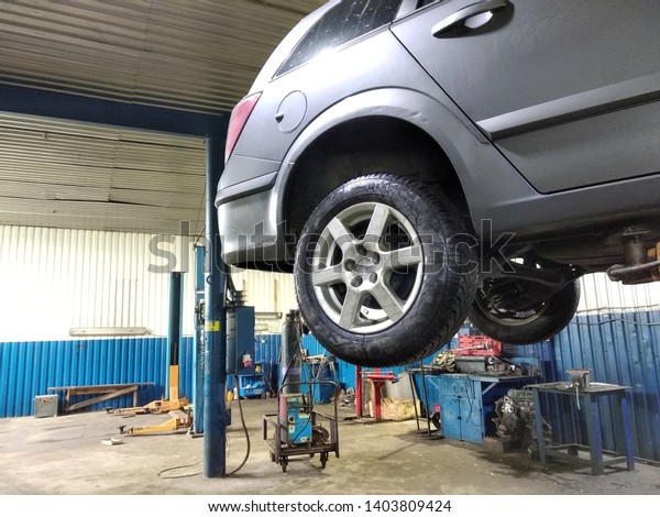 Ivano-Frankivsk, UKRAINE - December 25,\
2019: Automobile workshop interior with a car in repair. Vehicle\
diagnostics and\
maintenance.