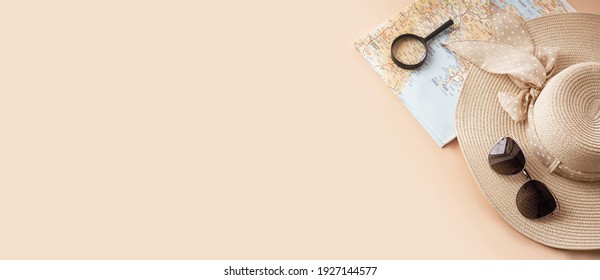 Ivanovo, Russia - February, 2021: Straw hat, map, sunglasses and magnifying glass on pastel background. Summer holiday, vacation, travel concept. Flat lay, top view, copy space. Banner