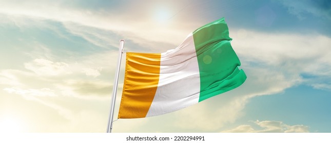 Ivory Coast national flag waving in beautiful sky. - Shutterstock ID 2202294991