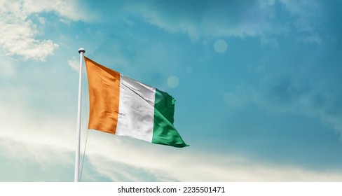 Ivory Coast national flag waving in beautiful sky. - Shutterstock ID 2235501471