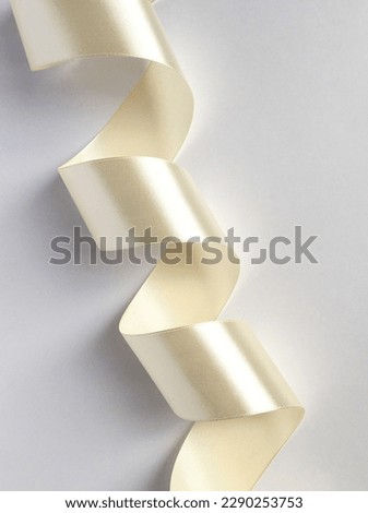 Ivory satin ribbon on a light background