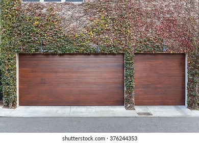 Ivy Covered Brown Three Car Garage Doors