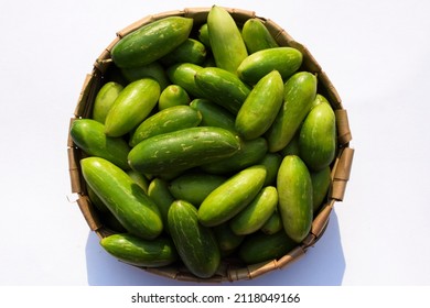 Ivy gourd or scarlet gourds known as Tindora or Ghola, green vegetables from tropical climate Indian Asian vegetables top view. Vegetables stacked heap in basket on white background