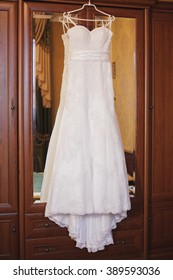 IWhite Wedding Dresses Hanging In The Closet. Beautiful Dress With A Train
