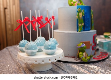 Izmail, Ukraine - May 2020. Festive candy bar for 5 years old boy birthday party. Blue cakepops with red bows. Sweets for family event. Cake with Teenage Mutant Ninja Turtles.