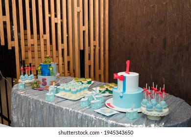 Izmail, Ukraine - May 2020 Festive candy bar for 1, 5 years old boys birthday party. Cake with red number 1, butterfly bow on shirt. Blue cakepops, cupcakes with red bows, Teenage Mutant Ninja Turtles