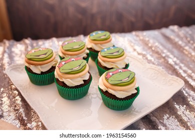 Izmail, Ukraine - May 2020. Festive candy bar for boy birthday party. Blue cupcakes with Teenage Mutant Ninja Turtles. Sweets for family event. 