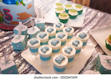 Izmail, Ukraine - May 2020. Festive candy bar for boy birthday party. Blue cupcakes with bears and Teenage Mutant Ninja Turtles, bombonieres. Sweets for family event. 