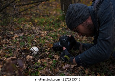 Izmail, Ukraine. October 2020. Man Making Photo Of Tiny Mushroom In Forest Using Camera And Flash Light. Macro World Photography, Nature Landscape.