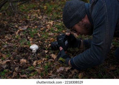 Izmail, Ukraine. October 2020. Man Making Photo Of Tiny Mushroom In Forest Using Camera And Flash Light. Macro World Photography, Nature Landscape.