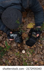 Izmail, Ukraine. October 2020. Unrecognizable Man Making Photo Of Tiny Mushroom In Forest Using Camera And Flash Light. Macro World Photography, Nature Landscape.