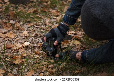 Izmail, Ukraine. October 2020. Unrecognizable Man Making Photo Of Tiny Mushroom In Forest Using Camera And Flash Light. Macro World Photography, Nature Landscape.